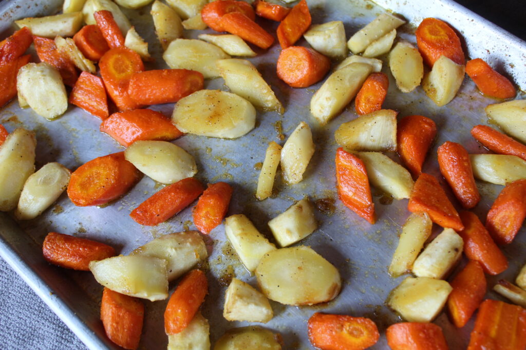 A sheet pan with the best maple roasted parsnips and carrots, straight from the oven. 