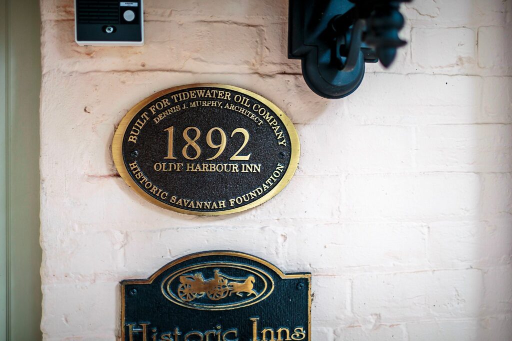 A historic plate hangs outside the entrance to the Olde Harbour Inn, located on Factors Walk, in the Historic District of Savannah, Georgia. The historic plate details the year the building was constructed, the architect and the Tide Water Oil Company.