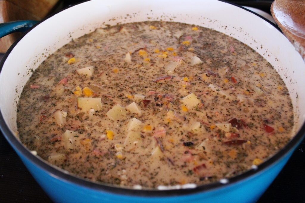 The best Ham, potato and corn chowder simmering away on the stove in a large enameled cast iron dutch oven made by Tramontina