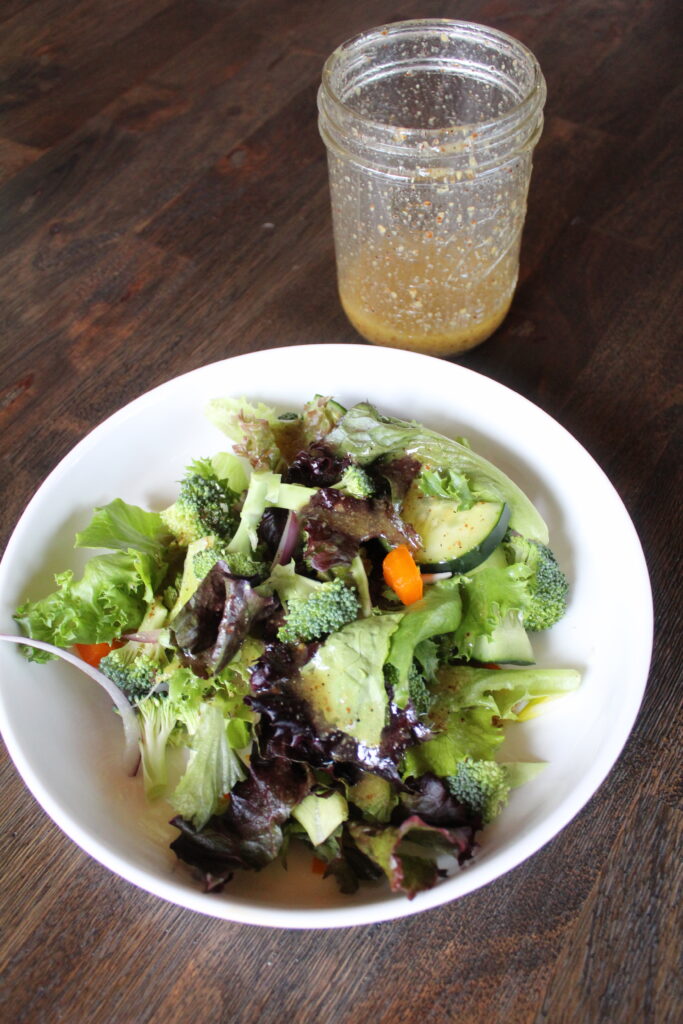 A simple salad with wholesome, delicious ingredients is topped with a homemade Maple Dijon Basil Vinaigrette